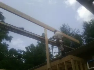 Carpenter setting a ridge beam over a new addition frame — Ice Dam Removal by Roofing Brothers in Rock Rapids