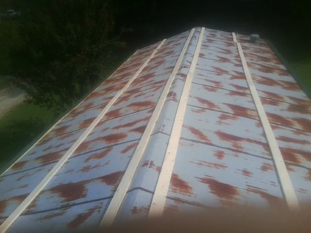 Rusted metal roof panels with new wood purlins before replacement — Storm Damage Roof Repair in Rock Rapids by Roofing Brothers